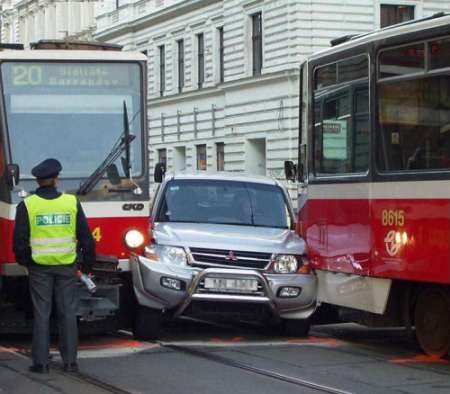 Funny Pictures of Car Squished Between Streetcars