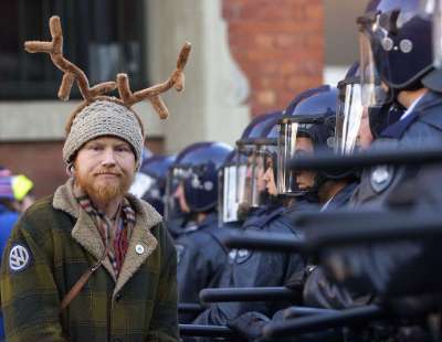 Picture of protestor with antlers and riot squad