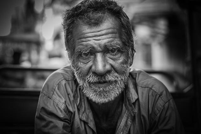 Head and shoulder shot of an older man with grizzly beard and mustache looking directly at us.