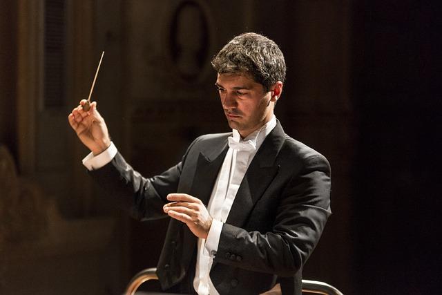 handsome orchestra conductor with music baton 