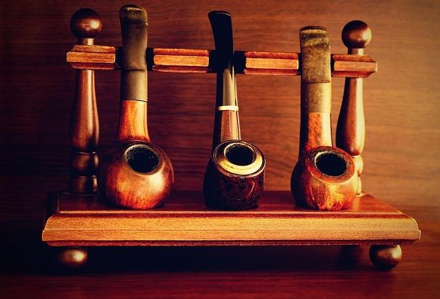 Three smoking pipes displayed on a pipe-smoking display rack.