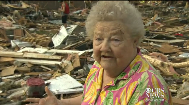 Woman finds dog amidst tornado damage.