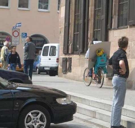 Funny Pictures of Kid on Bike Holding Board