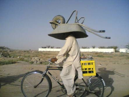 Funny Pictures of Bike Rider with Wheel Barrow on Head