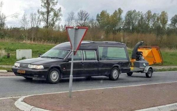 A Funny car picture of a hearse pulling a chipper