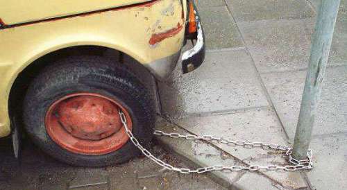 Funny Pictures of Car Chained To Pole